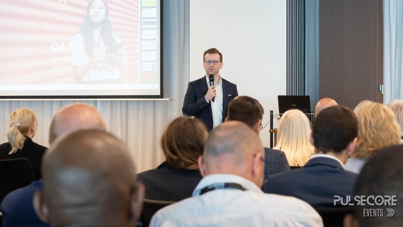 A speaker presents to seated delegates at the front of the room at a previous PulseCore event