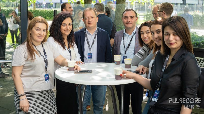 Delegates talk around a standing table during a networking break at a previous PulseCore event