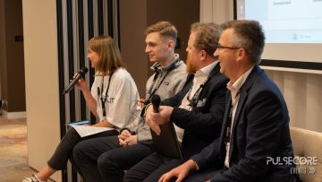 A panellist speaks into a microphone alongside fellow panellists at a previous PulseCore event
